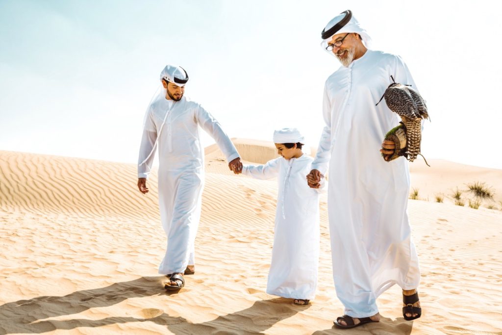 Eine Familie beim Spaziergang in einer Düne in Arabian Ranches, Dubai. Familienfreundliche Gemeinden in Dubai