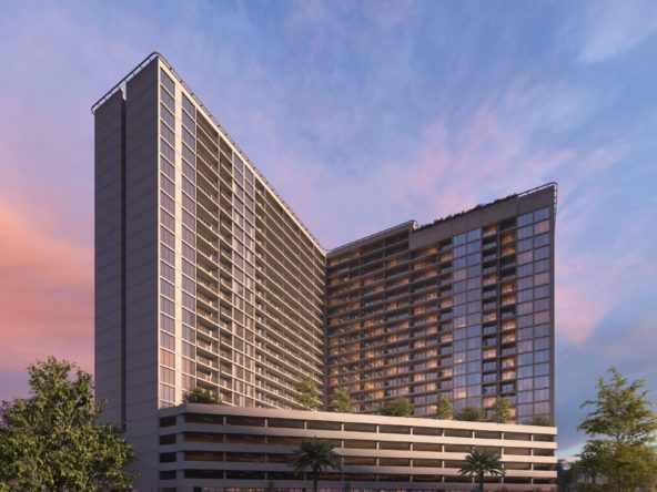 Exterior view of Luma Park Views tower, featuring expansive glass windows and lush greenery, set against a clear blue sky