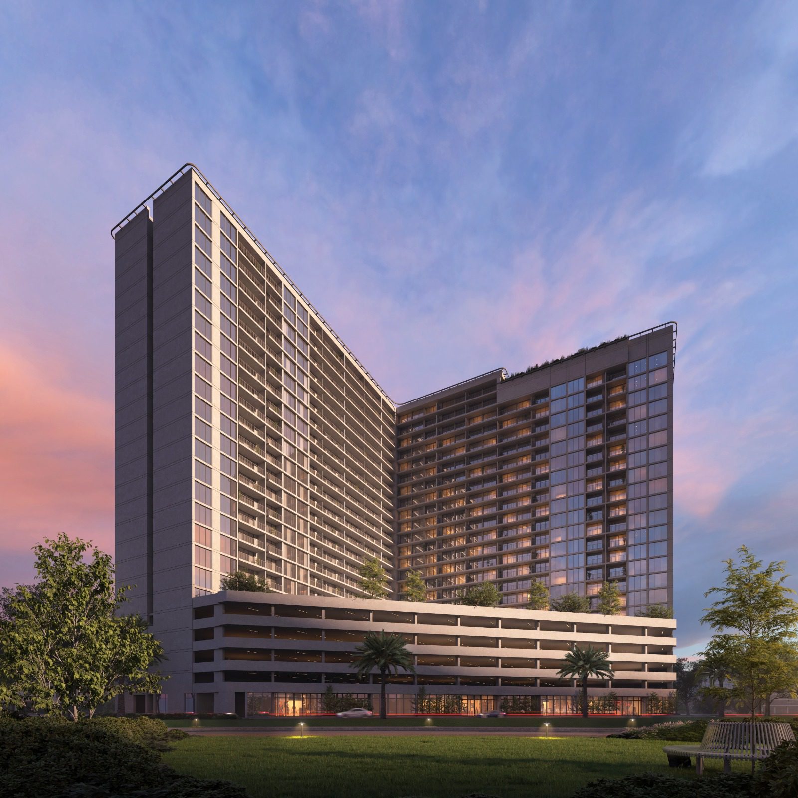 Exterior view of Luma Park Views tower, featuring expansive glass windows and lush greenery, set against a clear blue sky